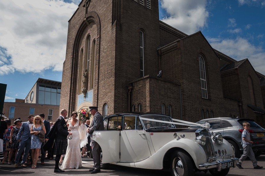 Bride and groom and wedding car outside church
