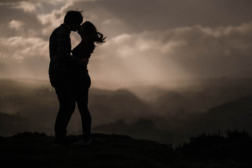 A Couple kiss at Curbar Edge in the Derbyshire Peak District