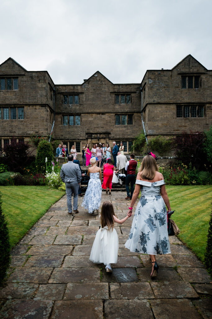 wedding guests outside Eyam Hall wedding guests outside Eyam Hall