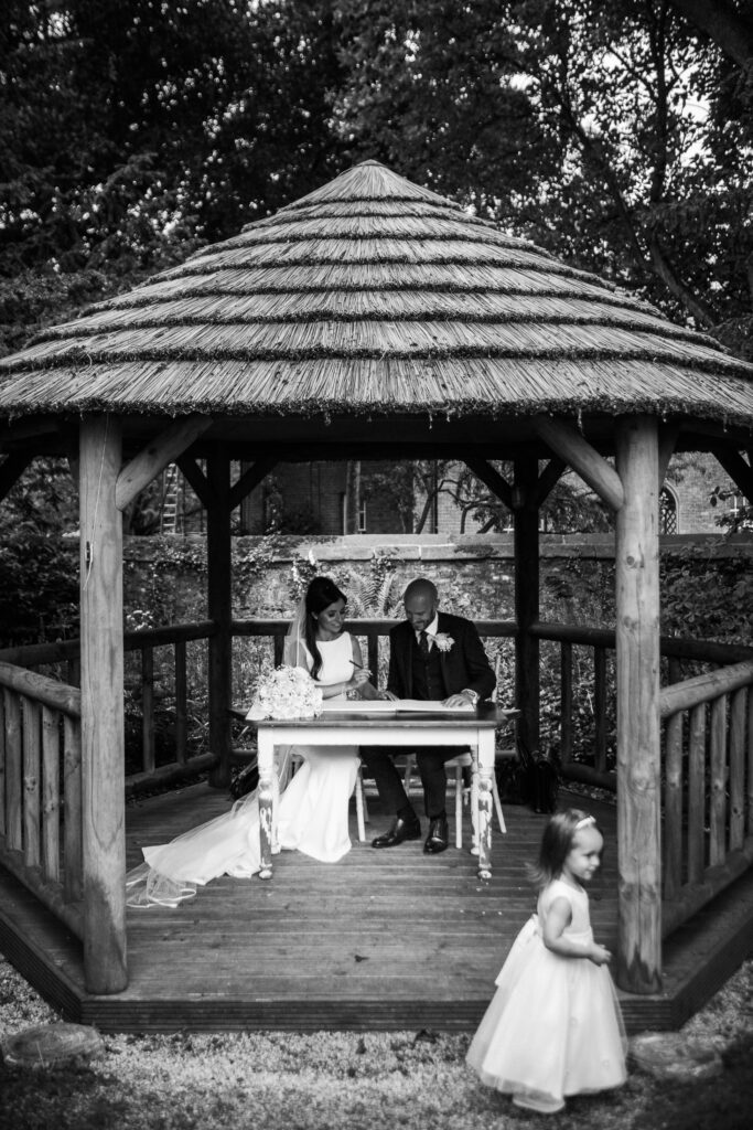Eyam Hall Wedding Photographer 12 Signing marriage register in pavilion at Eyam Hall