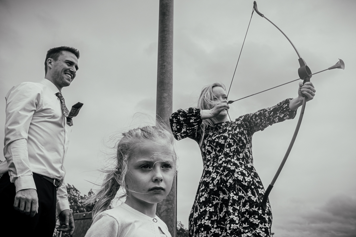 What is Documentary Wedding Photography? 1 Wedding guests play with bow and arrow - Documentary Wedding Photographer Derby