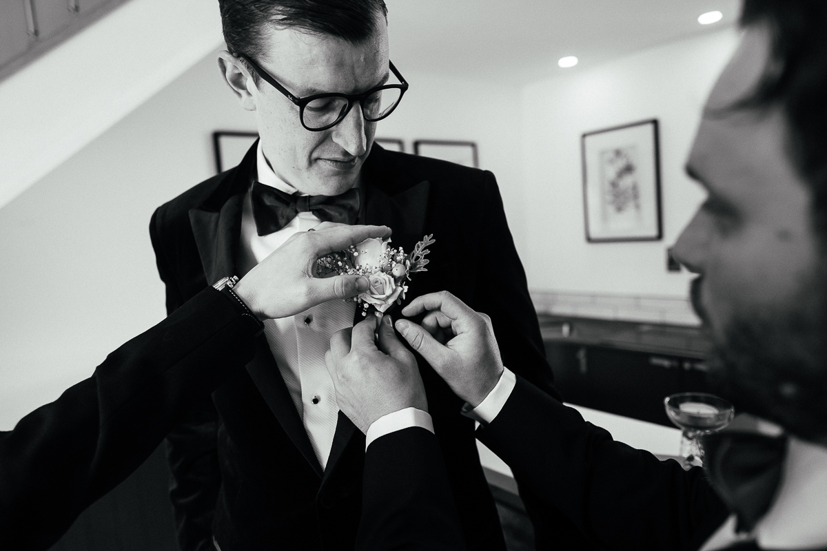The Ultimate Derbyshire Garden Wedding? 3 Groomsmen helping pin flower to groom